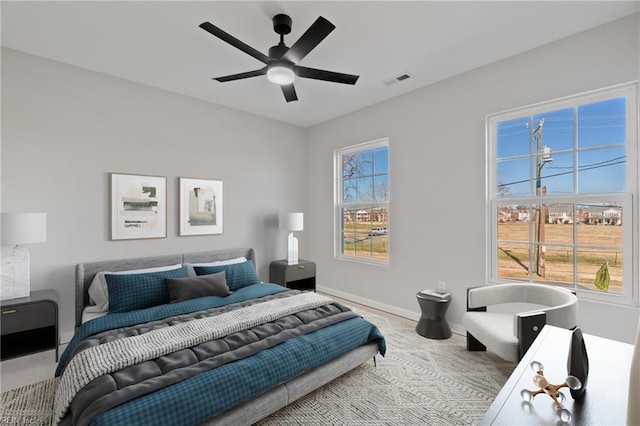 bedroom with multiple windows, baseboards, visible vents, and ceiling fan