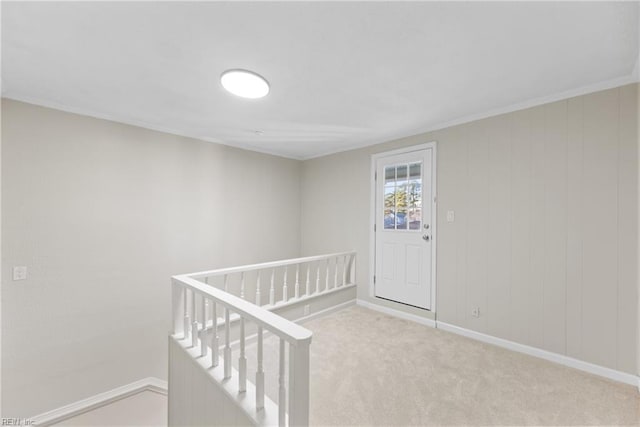 hall featuring an upstairs landing, carpet flooring, and baseboards