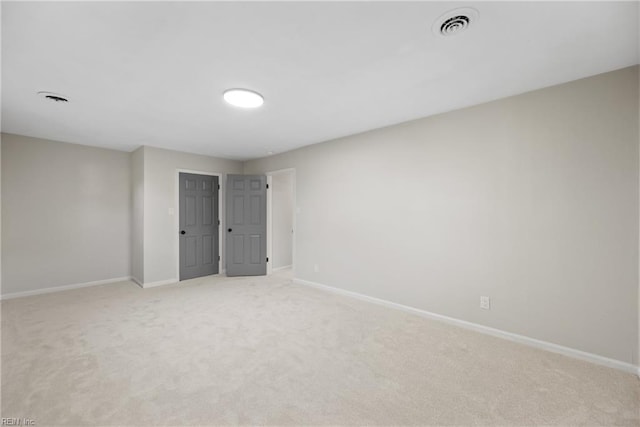 unfurnished bedroom with baseboards, light carpet, and visible vents