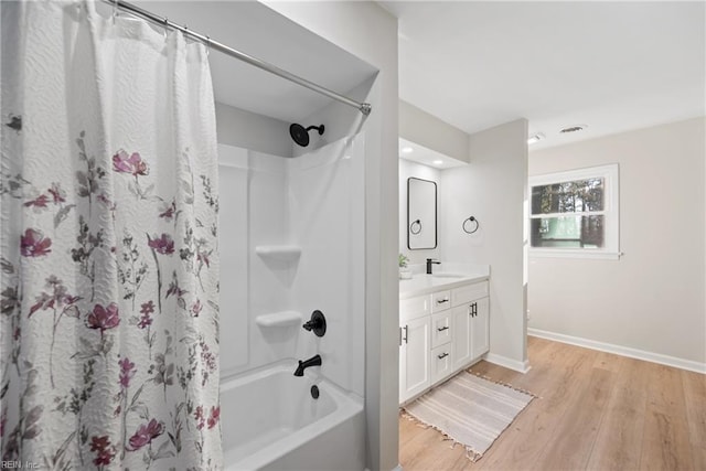 full bath featuring shower / bath combo with shower curtain, vanity, baseboards, and wood finished floors