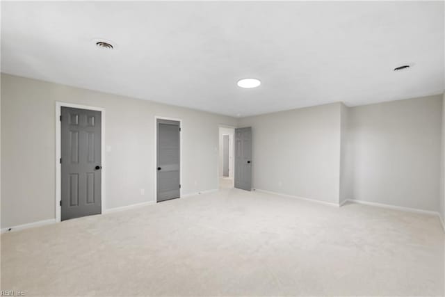 unfurnished bedroom with light carpet, visible vents, and baseboards