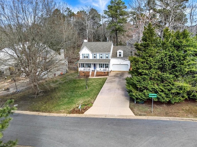 view of front of home featuring a front lawn, a porch, a chimney, a garage, and driveway