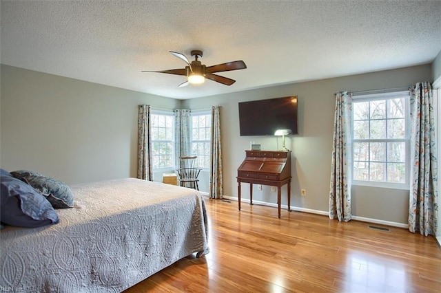 bedroom featuring visible vents, light wood-type flooring, and baseboards