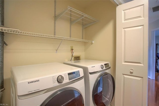 washroom featuring laundry area, visible vents, and separate washer and dryer