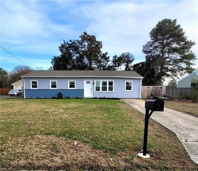 ranch-style home with a front yard and fence