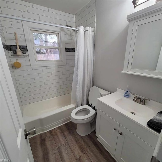 bathroom with shower / bath combo with shower curtain, toilet, wood finished floors, and vanity