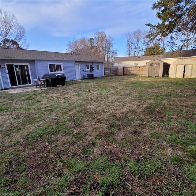 view of yard featuring an outdoor structure, fence, a shed, and a patio area