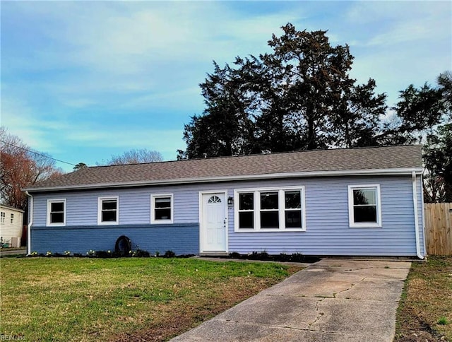 single story home with brick siding, a shingled roof, a front lawn, and fence