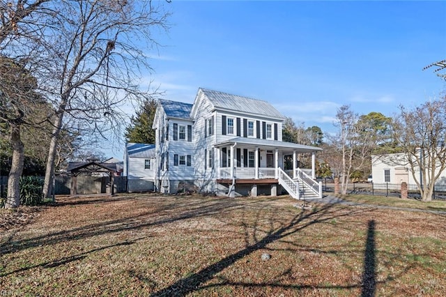 colonial inspired home featuring a front yard, fence, and covered porch