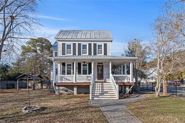 view of front of property with fence, stairway, covered porch, a front yard, and metal roof