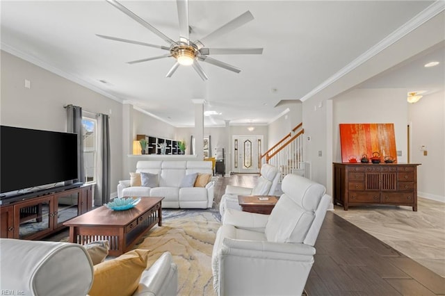 living room featuring crown molding, a ceiling fan, stairs, and baseboards