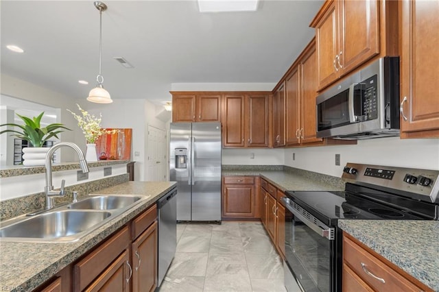 kitchen with a sink, brown cabinets, marble finish floor, and stainless steel appliances