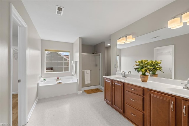 full bath featuring a shower stall, a garden tub, double vanity, and a sink