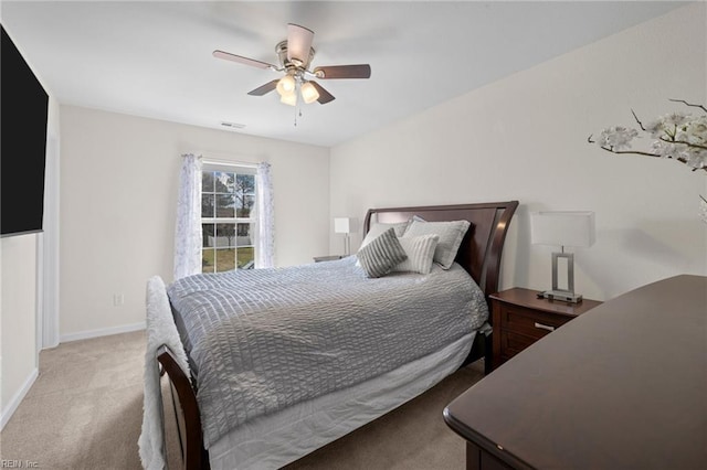 bedroom with baseboards, light carpet, visible vents, and a ceiling fan