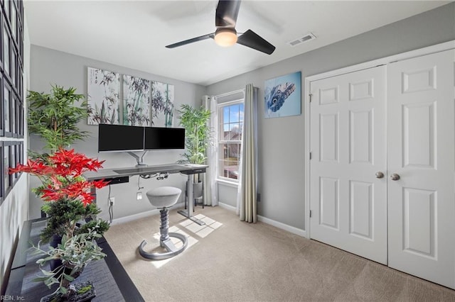 carpeted office space featuring visible vents, ceiling fan, and baseboards