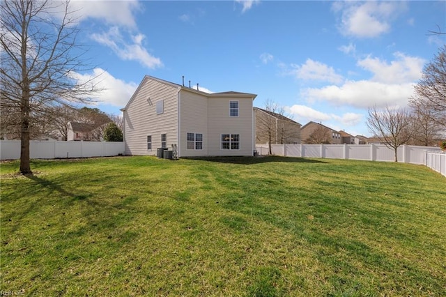 rear view of property featuring a fenced backyard, central AC, and a yard