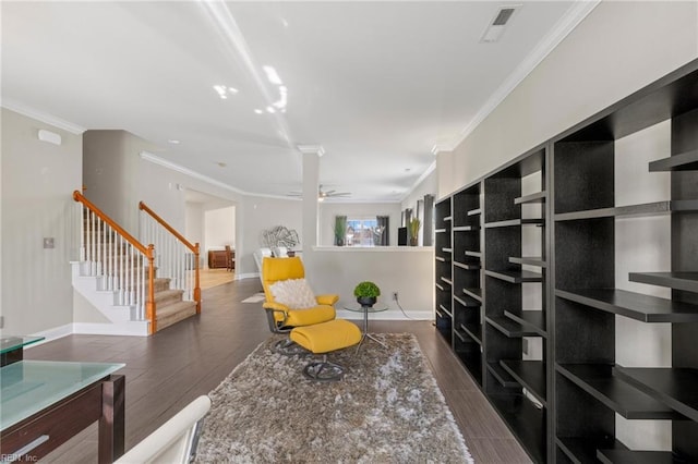 sitting room featuring wood finished floors, baseboards, visible vents, ornamental molding, and stairs