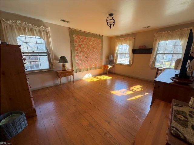 bedroom with hardwood / wood-style floors, baseboards, and visible vents