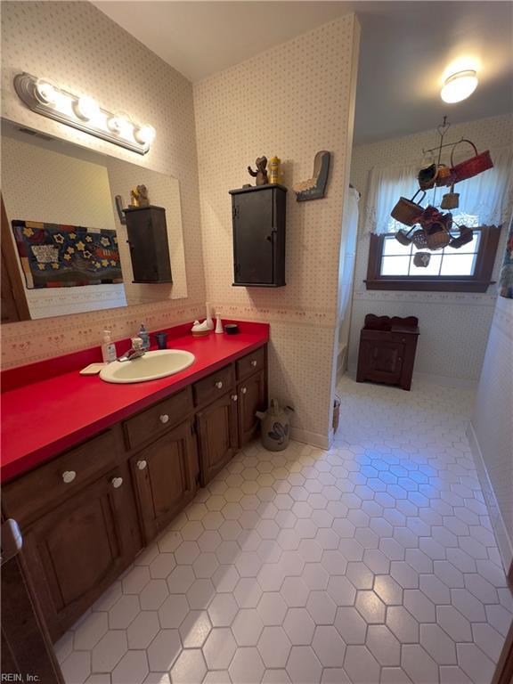 full bathroom with tile patterned floors, a shower with shower curtain, wallpapered walls, baseboards, and vanity