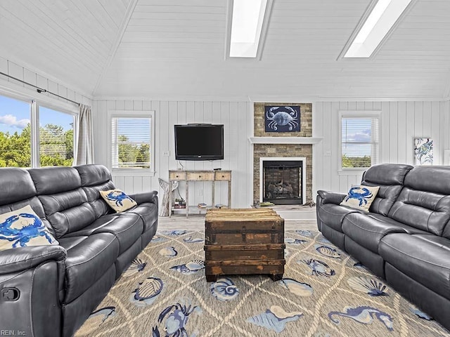 living room featuring lofted ceiling with skylight, a fireplace, and wood finished floors