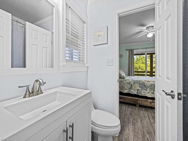 bathroom featuring ceiling fan, toilet, ornamental molding, wood finished floors, and vanity