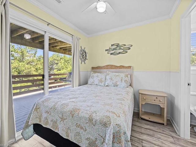 bedroom featuring ceiling fan, wood finished floors, wainscoting, and ornamental molding