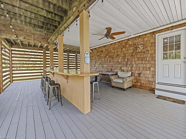 wooden terrace featuring outdoor dry bar and a ceiling fan