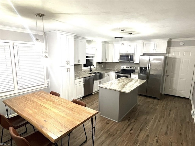 kitchen featuring backsplash, a center island, appliances with stainless steel finishes, white cabinetry, and dark wood-style flooring