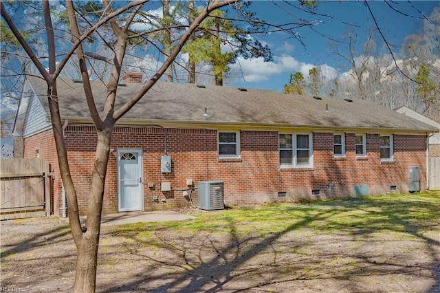 back of property featuring fence, a yard, central AC, crawl space, and brick siding