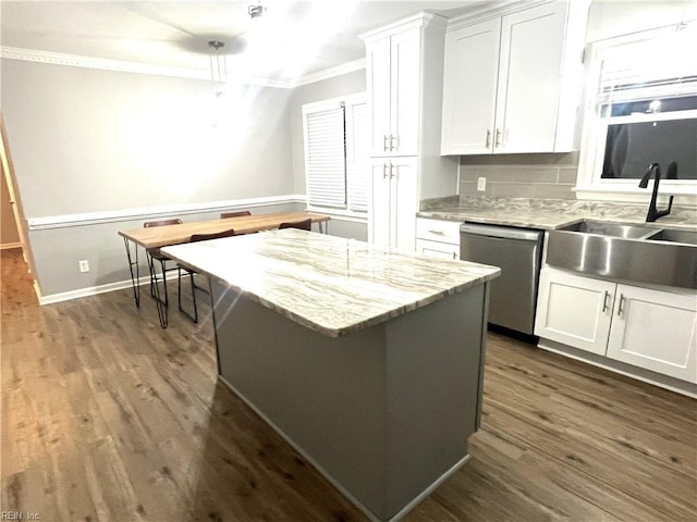 kitchen with ornamental molding, dishwasher, white cabinets, and a sink