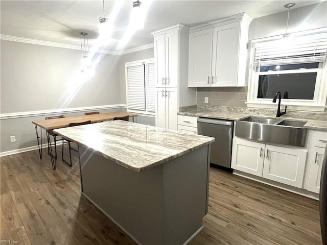 kitchen with a sink, white cabinets, crown molding, and stainless steel dishwasher