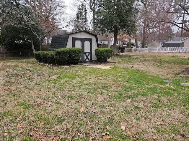 view of yard with an outbuilding, a storage unit, and fence