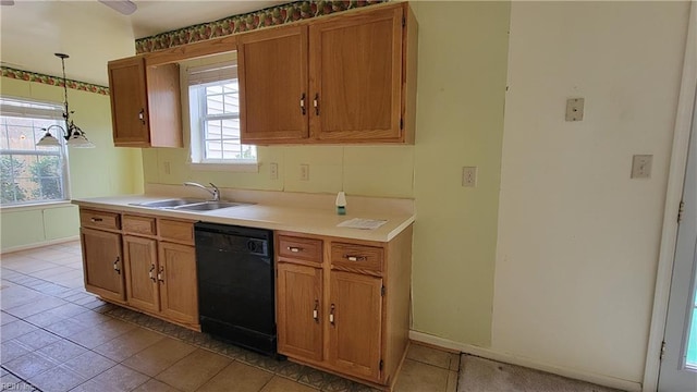 kitchen with brown cabinets, dishwasher, light countertops, and a sink