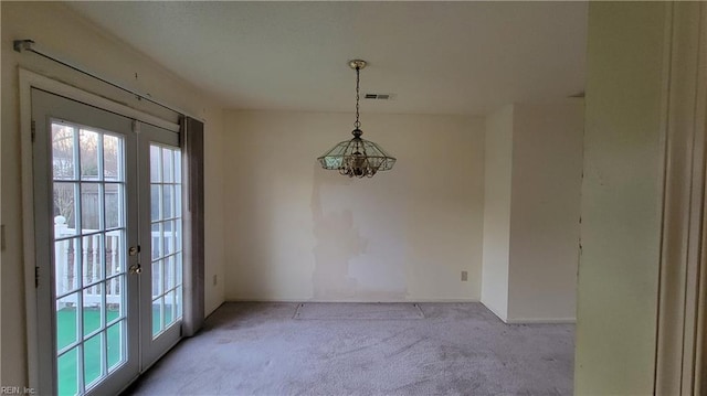 unfurnished dining area with visible vents, french doors, and carpet