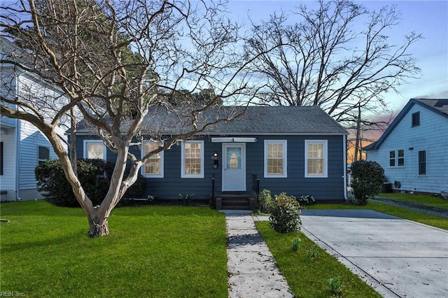 view of front facade featuring a front yard and roof with shingles