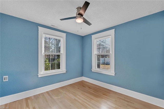 unfurnished room featuring ceiling fan, baseboards, a textured ceiling, and wood finished floors