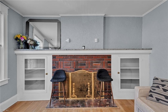 interior details with built in shelves, crown molding, and wood finished floors