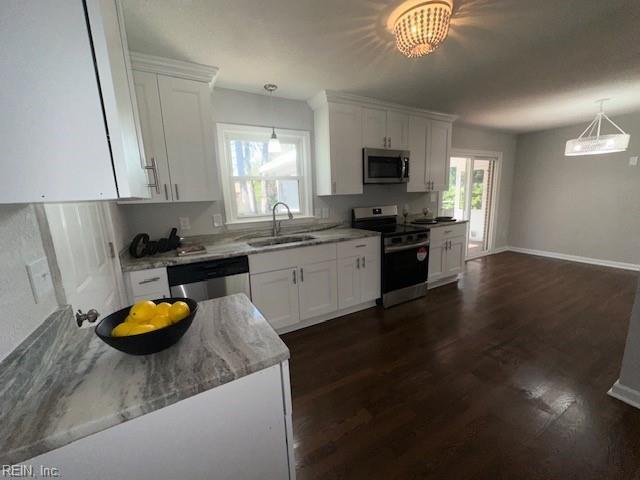 kitchen with a sink, white cabinets, light stone counters, and stainless steel appliances