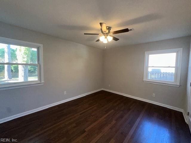 empty room with ceiling fan, baseboards, and dark wood-style floors