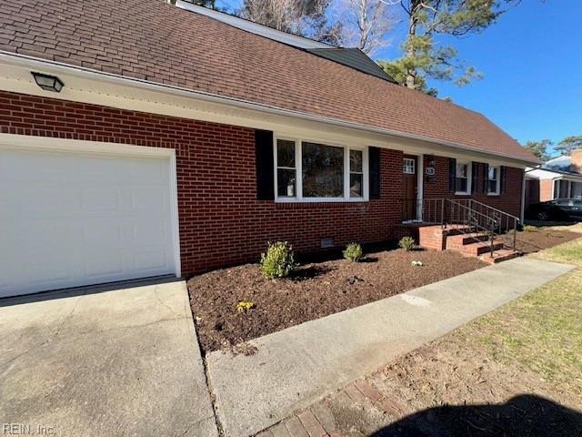 single story home with driveway, roof with shingles, an attached garage, crawl space, and brick siding