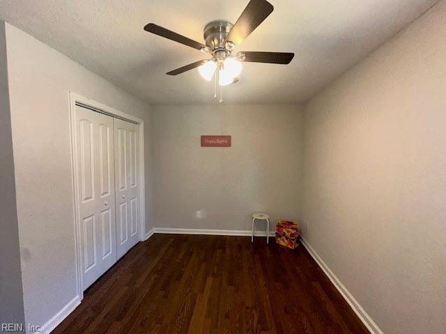 unfurnished bedroom with wood finished floors, baseboards, a closet, and ceiling fan