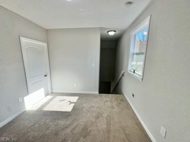 unfurnished room featuring baseboards and carpet