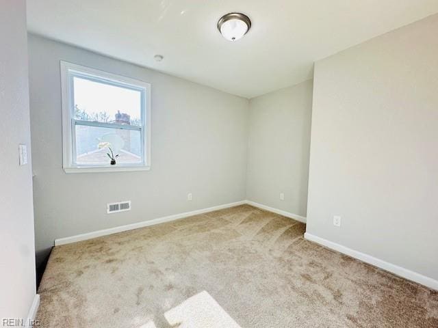 carpeted spare room with baseboards and visible vents