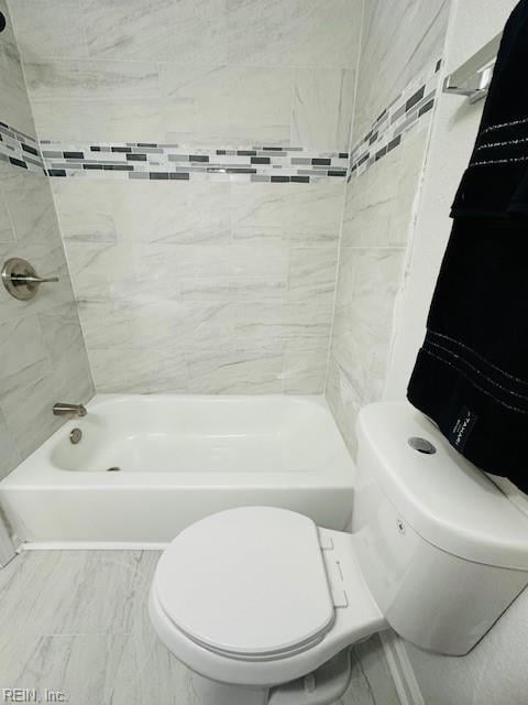 full bathroom featuring toilet, marble finish floor, and shower / washtub combination