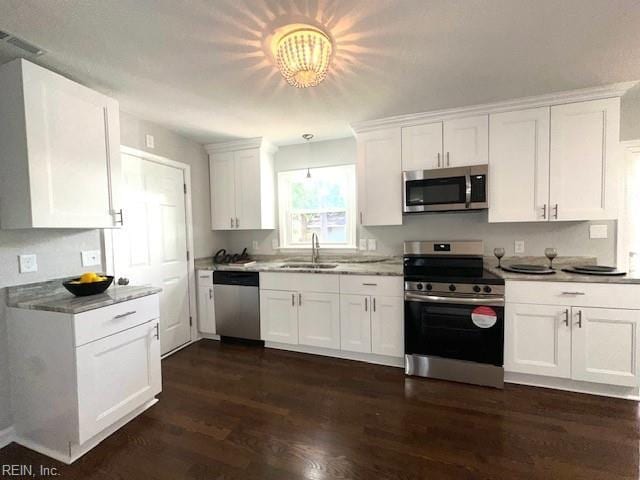 kitchen featuring a sink, dark wood finished floors, white cabinetry, appliances with stainless steel finishes, and light countertops