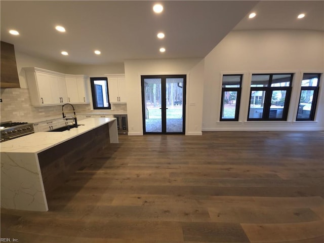 kitchen featuring a sink, open floor plan, gas range oven, wine cooler, and white cabinets