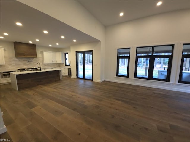 kitchen with open floor plan, backsplash, white cabinets, and dark wood-style flooring