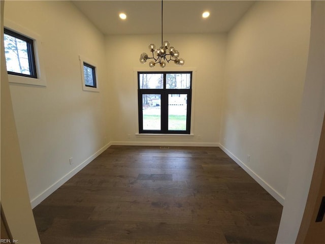 unfurnished room featuring dark wood finished floors, recessed lighting, baseboards, and a chandelier