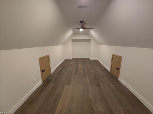 additional living space with a ceiling fan, baseboards, visible vents, dark wood-style flooring, and vaulted ceiling