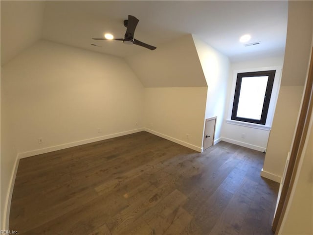 additional living space featuring lofted ceiling, baseboards, visible vents, and dark wood-style flooring